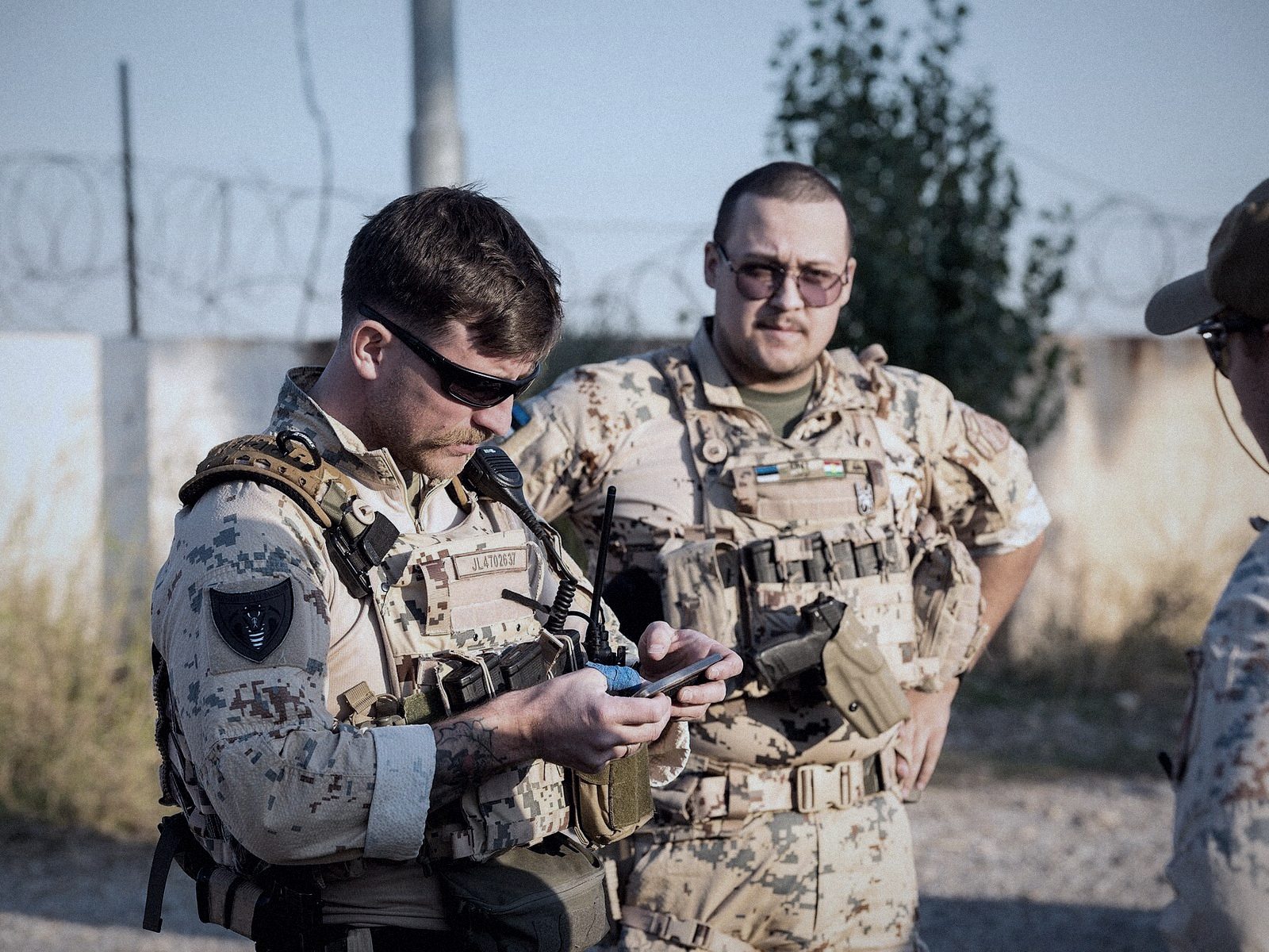 Soldiers checking a mobile device during a field exercise