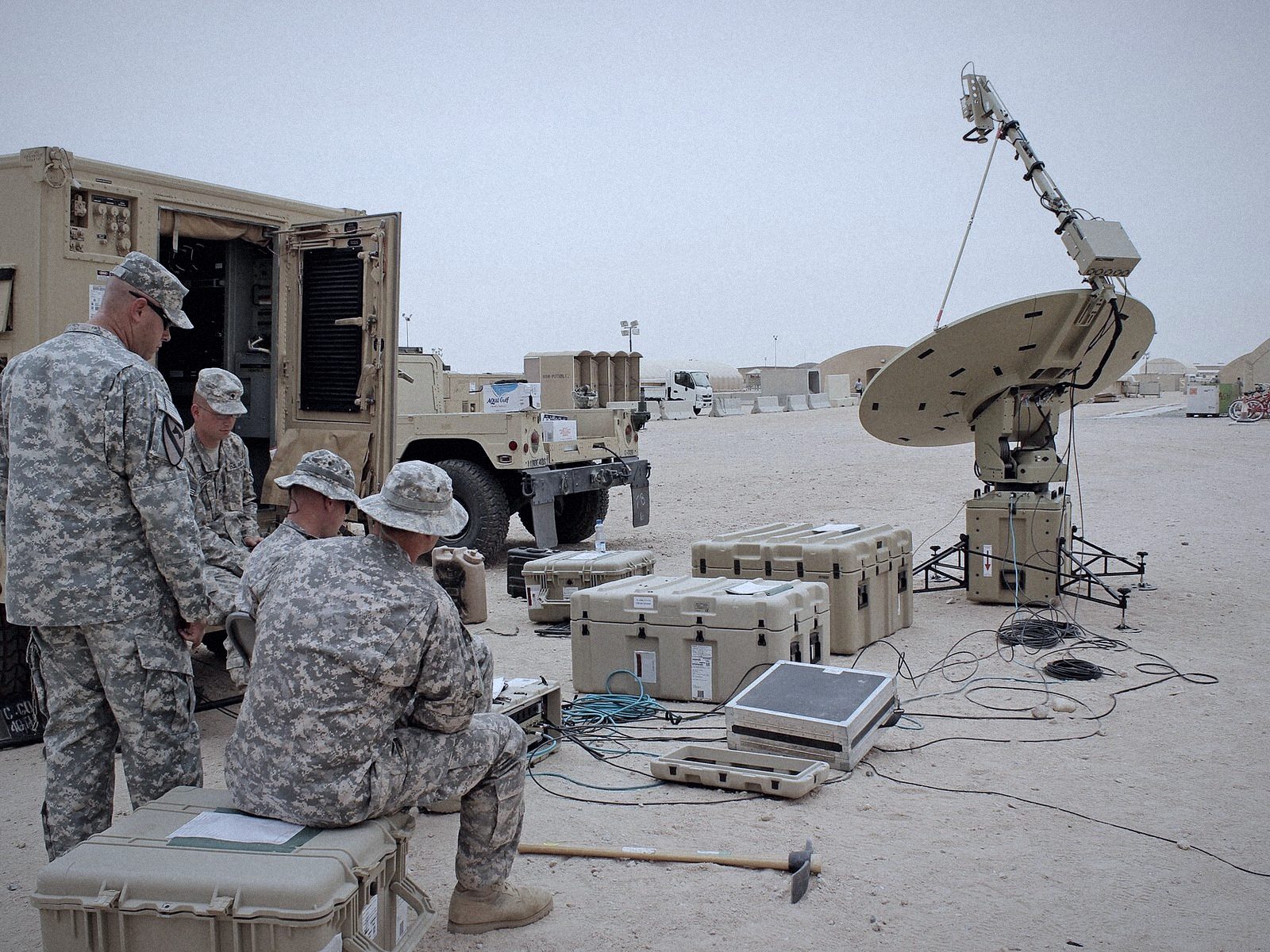 Team setting up a satellite communications antenna